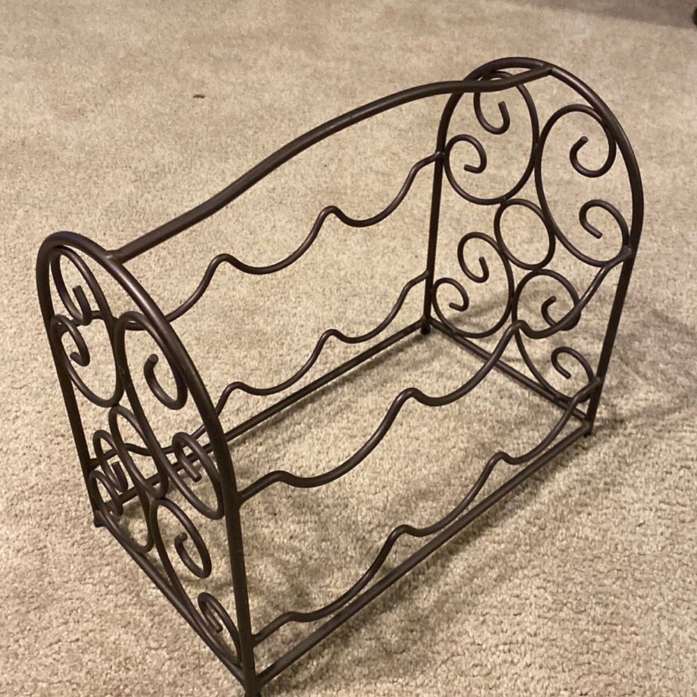Scroll design metal wine rack in a dark bronze color holds at least six bottles